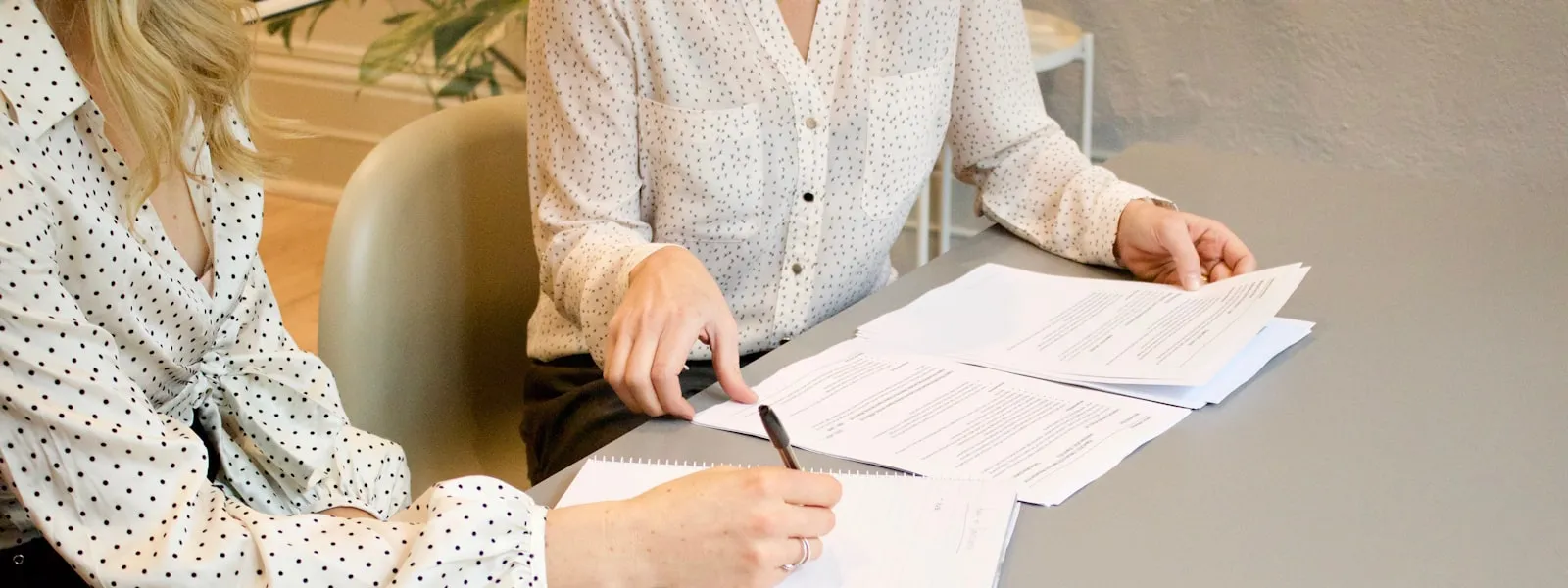 Kaks naist allkirjastavad laua taga dokumente — LEI koodi taotlemiseks vajalikud dokumendid